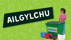 Cartŵn o fenyw ifanc yn sefyll y tu ôl i nifer o gynwysyddion ailgylchu a ddefnyddir yn ninas Caerdydd. Mae'r testun o dan y cartŵn yn dweud "Ailgylchu!"